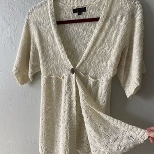 Small cream colored short sleeve knitted style blouse with front button